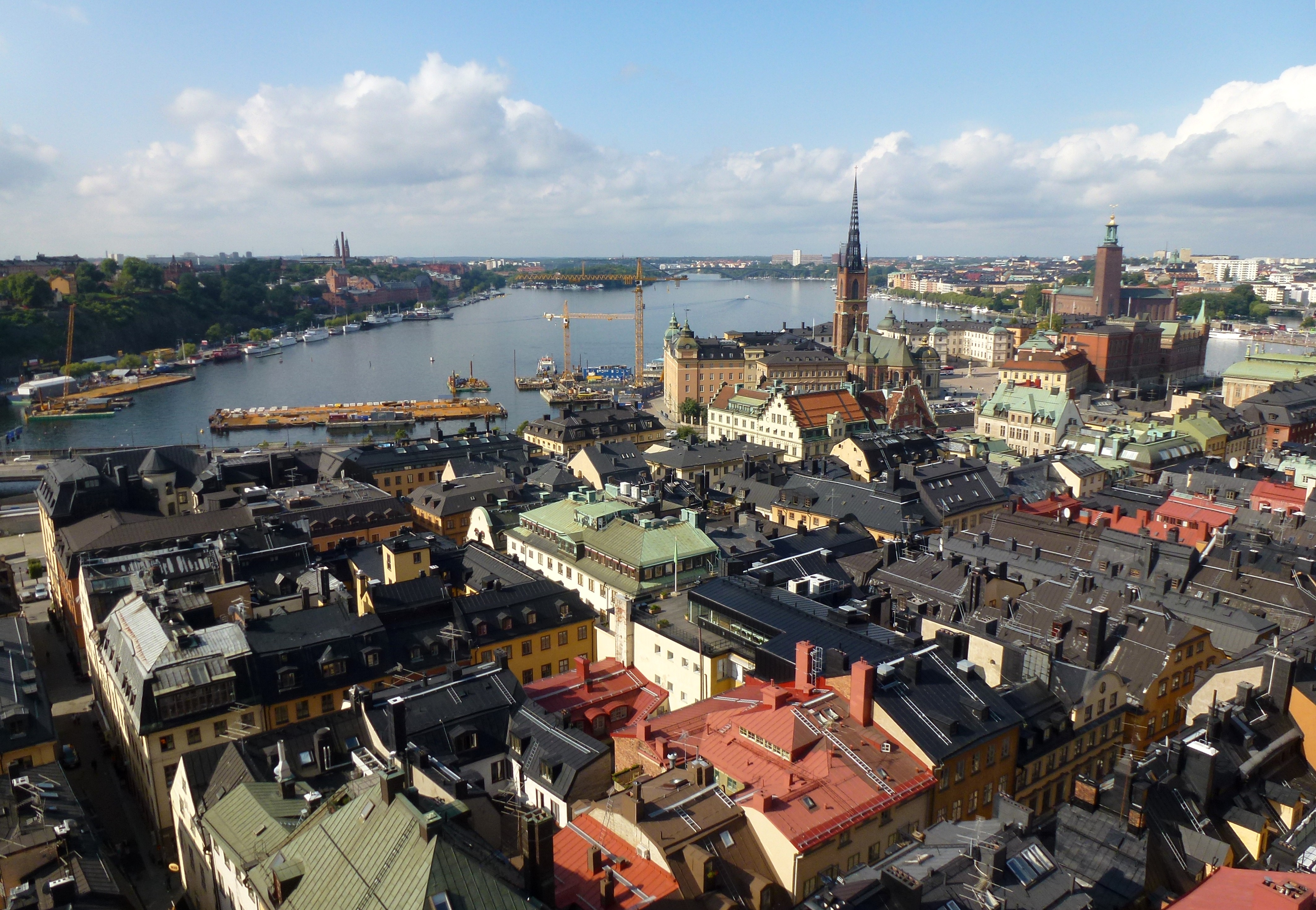 The wide silver water of Riddarfjärden, Gamla Stan's old façades along the near shore, the city low across the bay.